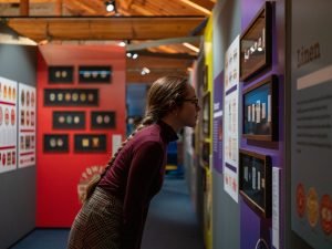 A visitor examines several framed labels in the exhibition 'Grand Stuff: Label Art in Ireland'