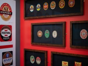 A photo showing several beer labels displayed in frames as part of the exhibition 'Grand Stuff: Label Art in Ireland.'