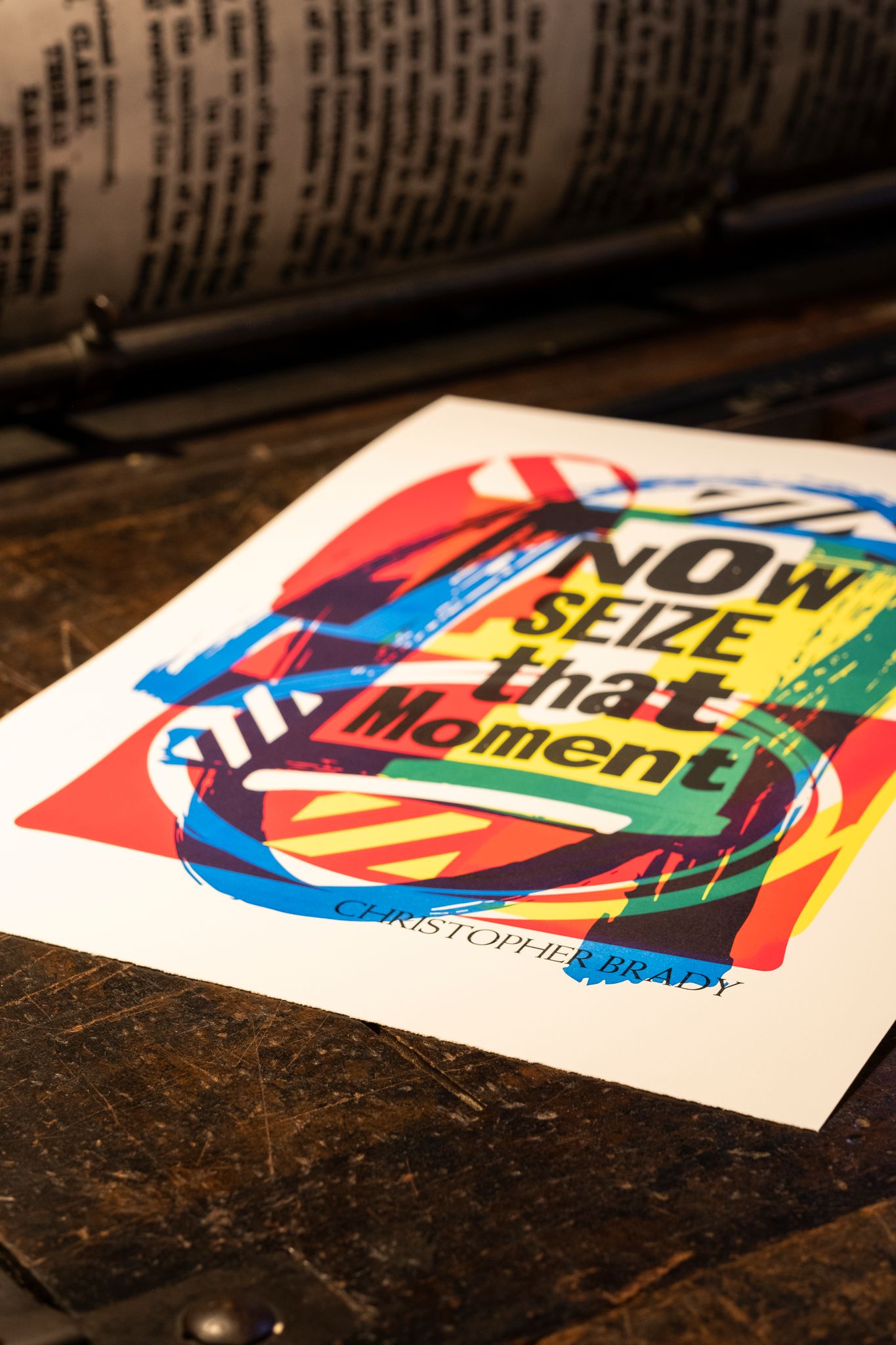 A colourful print by Maser reading 'Now Seize that Moment'