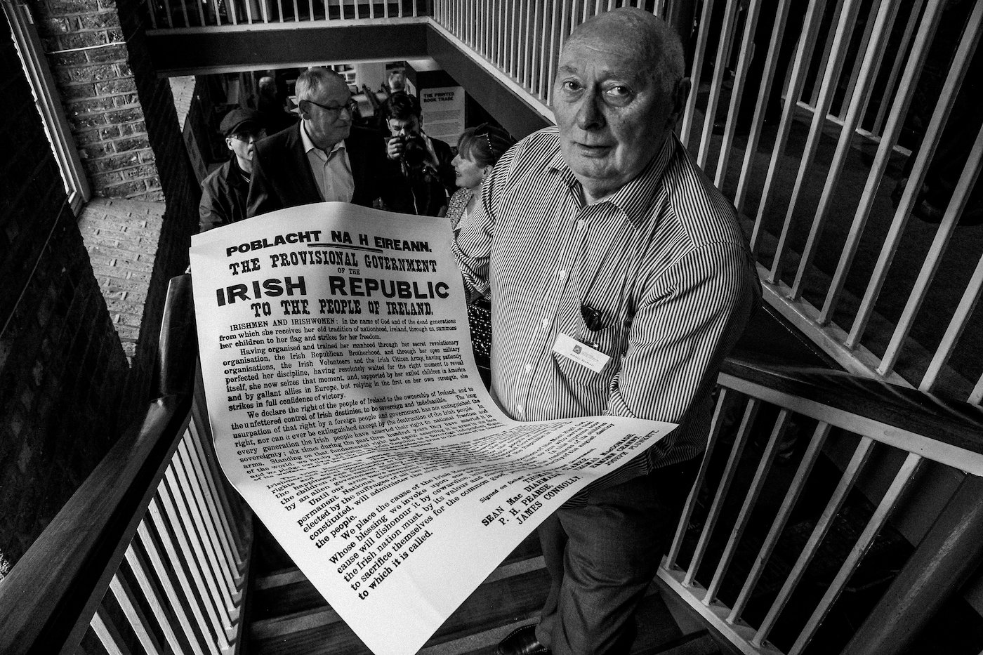 A retired printer holds up a replica print of the Irish Proclamation