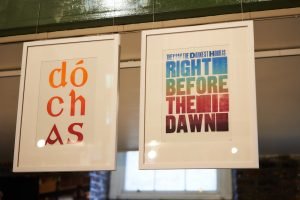 Locked Up in Lockdown installation shot, prints reading 'Dochas' and 'They Say the Darkest Hour is Right Before the Dawn'