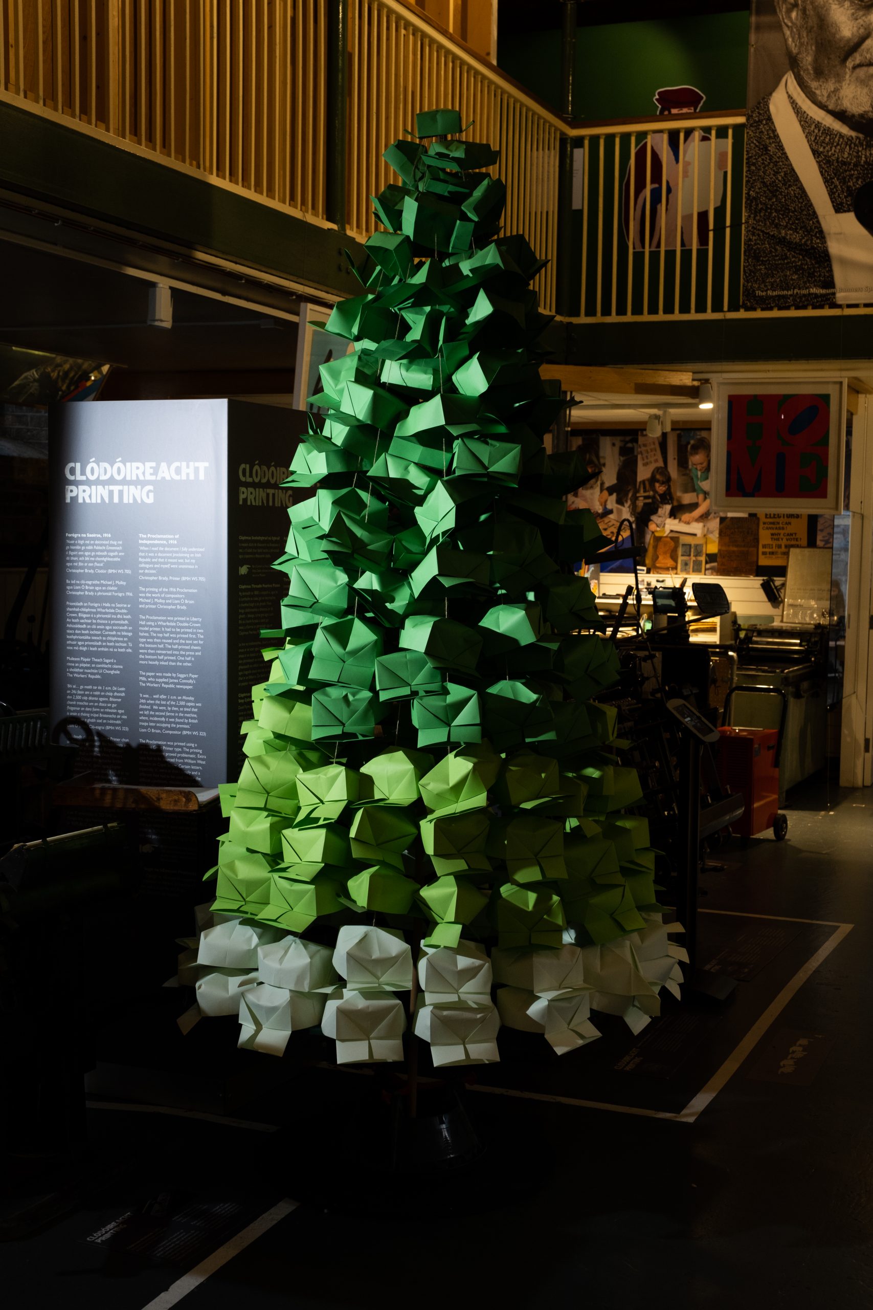 A life-size christmas tree made out of white and green printer's hats