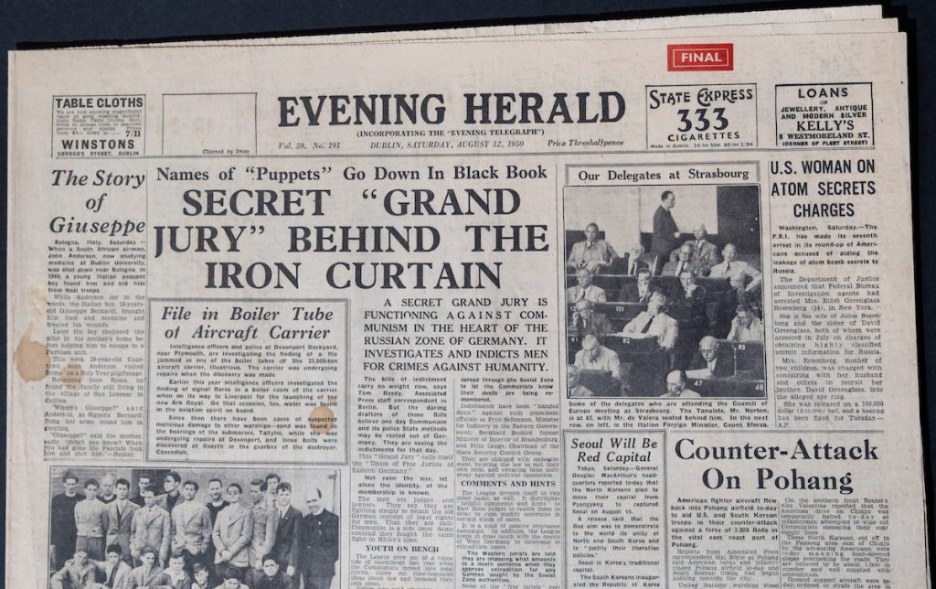 A close-up shot of the lead article of the newspaper. The subheading reads, ‘Names of “Puppets” Go Down in Black Book. The main headline reads, ‘Secret “Grand Jury” Behind the Iron Curtain’. A close-up shot of the lead article of the newspaper. The subheading reads, ‘Names of “Puppets” Go Down in Black Book. The main headline reads, ‘Secret “Grand Jury” Behind the Iron Curtain’.