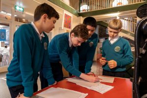 Students gather around a table and brainstorm ideas