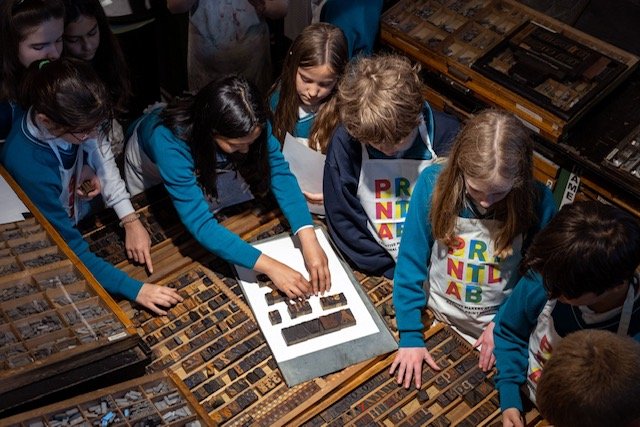 Students use wood type to compose words
