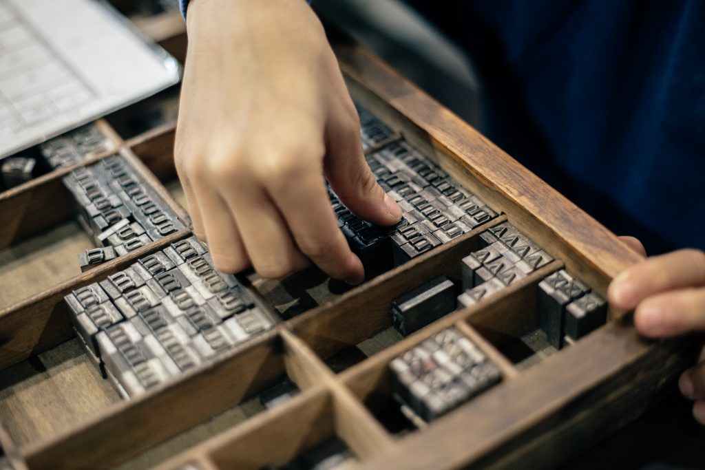 A child reaches for a metal piece of type in a type case