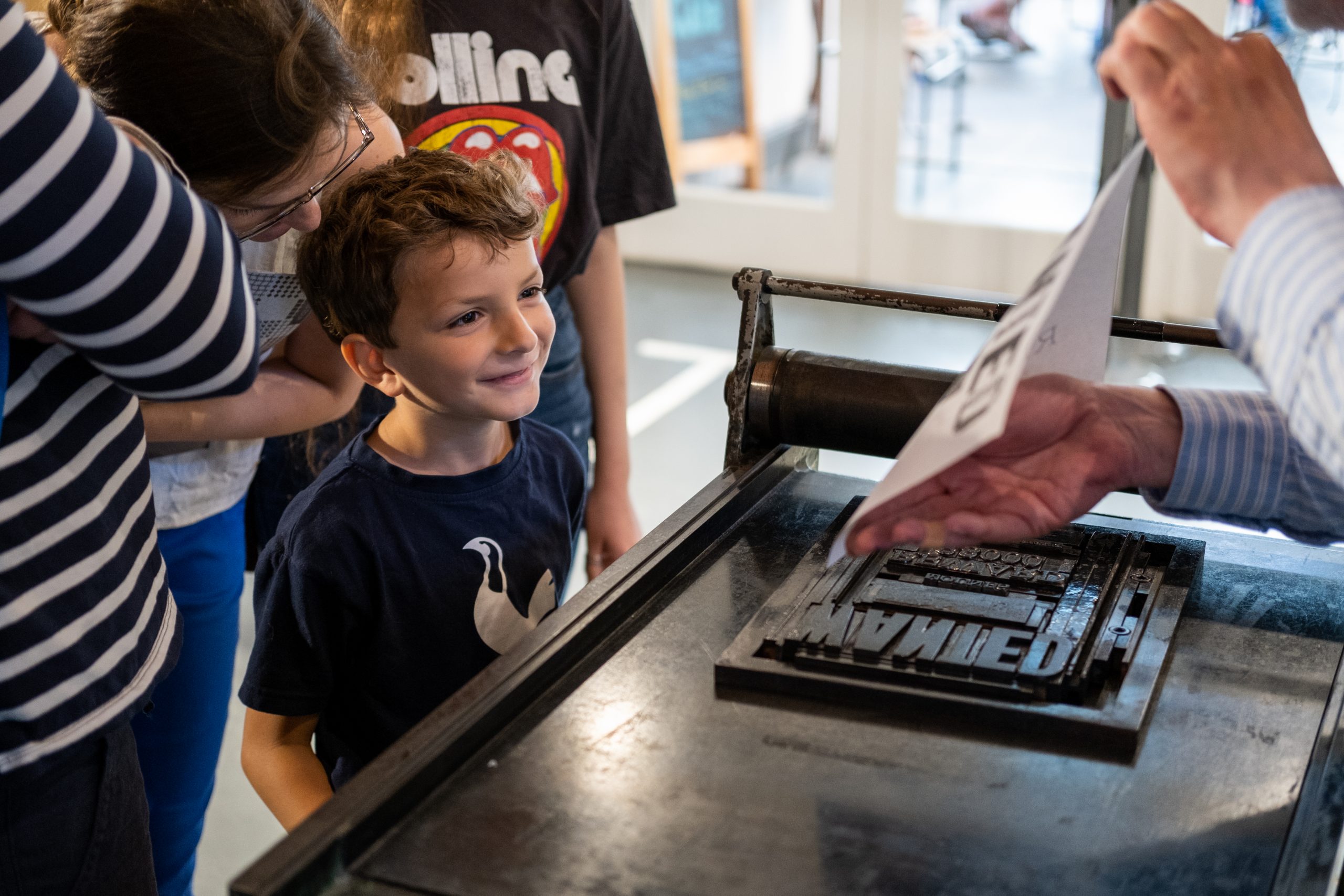 A child smiles after seeing their name printed on a poster.