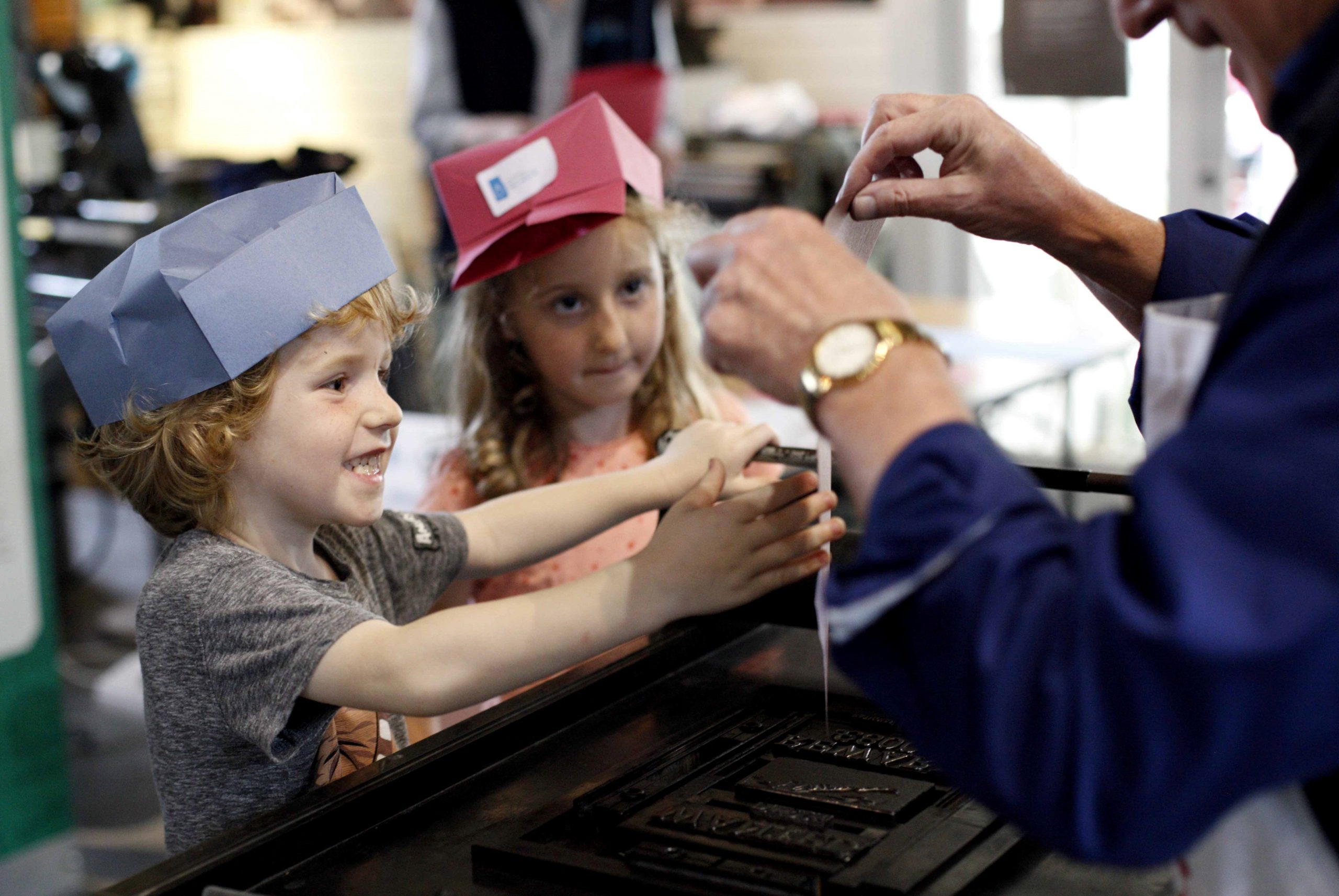 A child smiles as they see their name printed on a poster at the Museum.