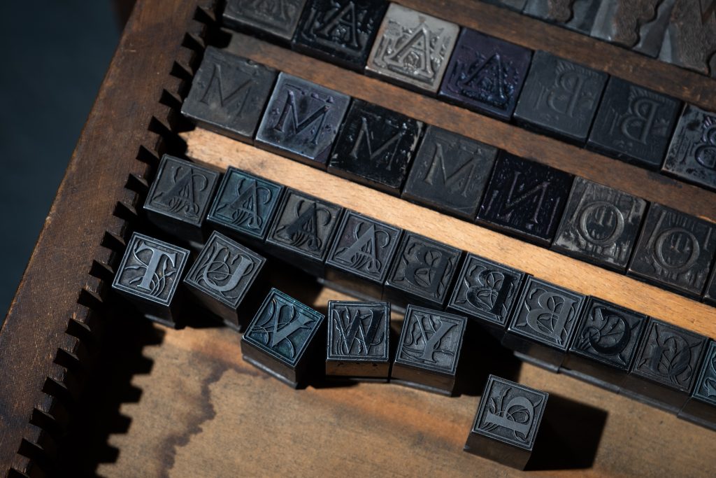 A close-up image of a type case containing decorative metal type