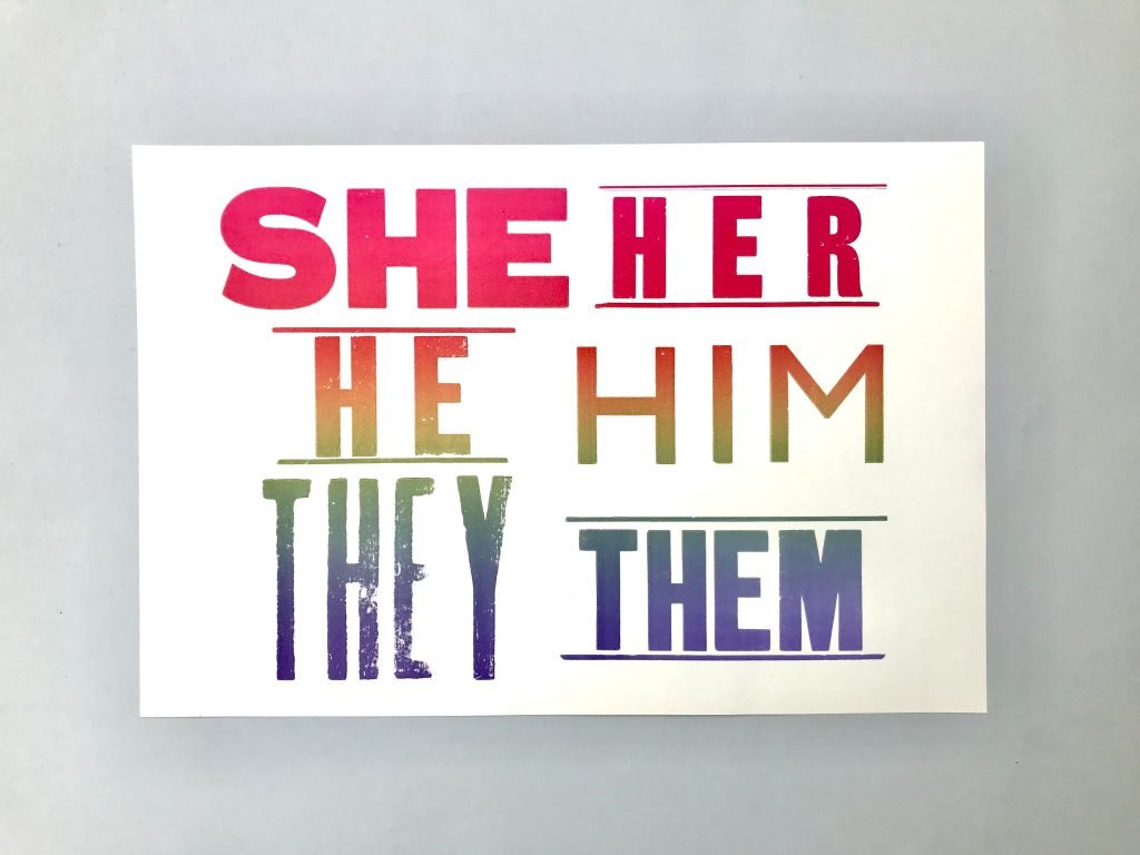 Letterpress print poster containing the text 'She her, he him, they them' printed in rainbow ink