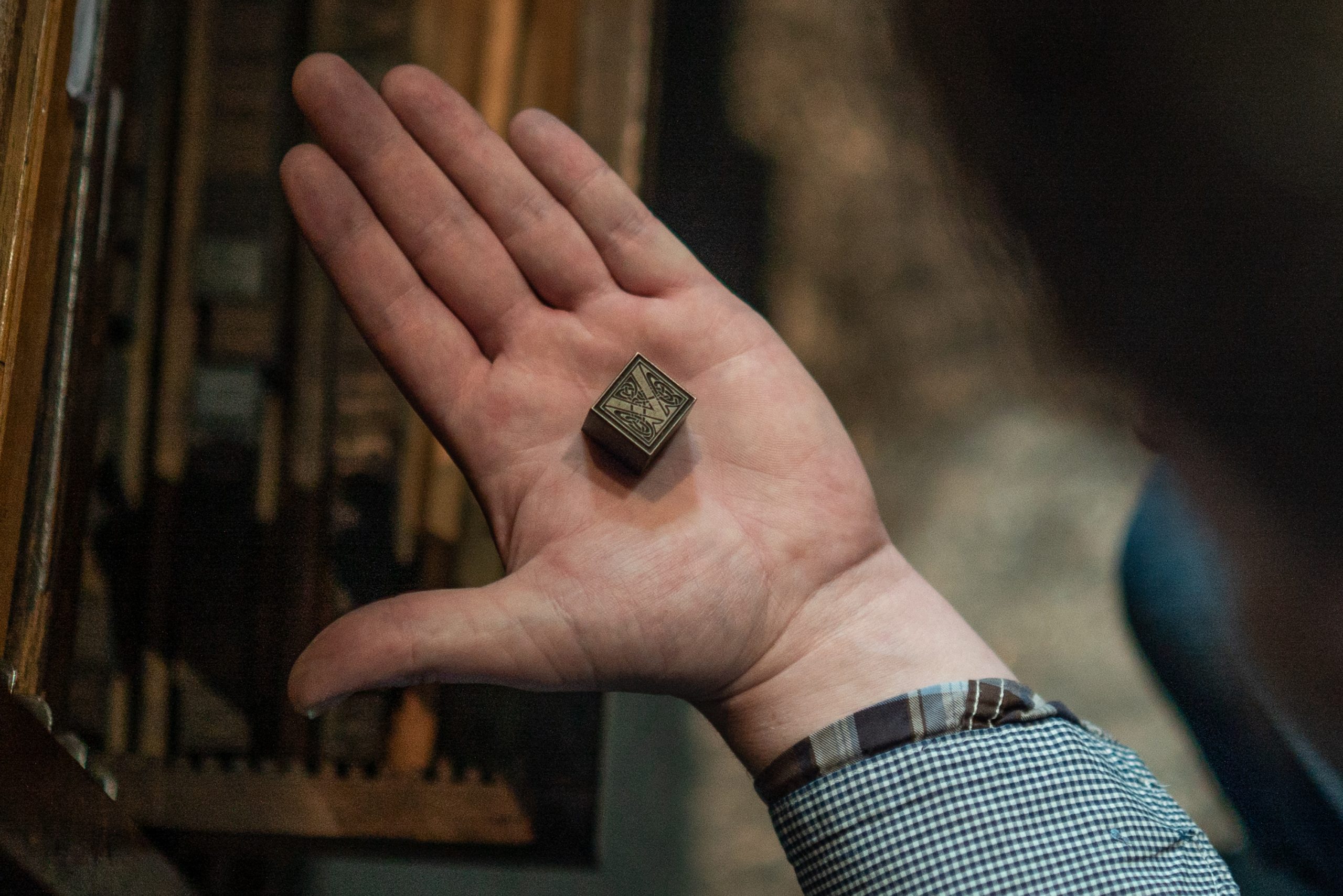 Piece of type held in hand