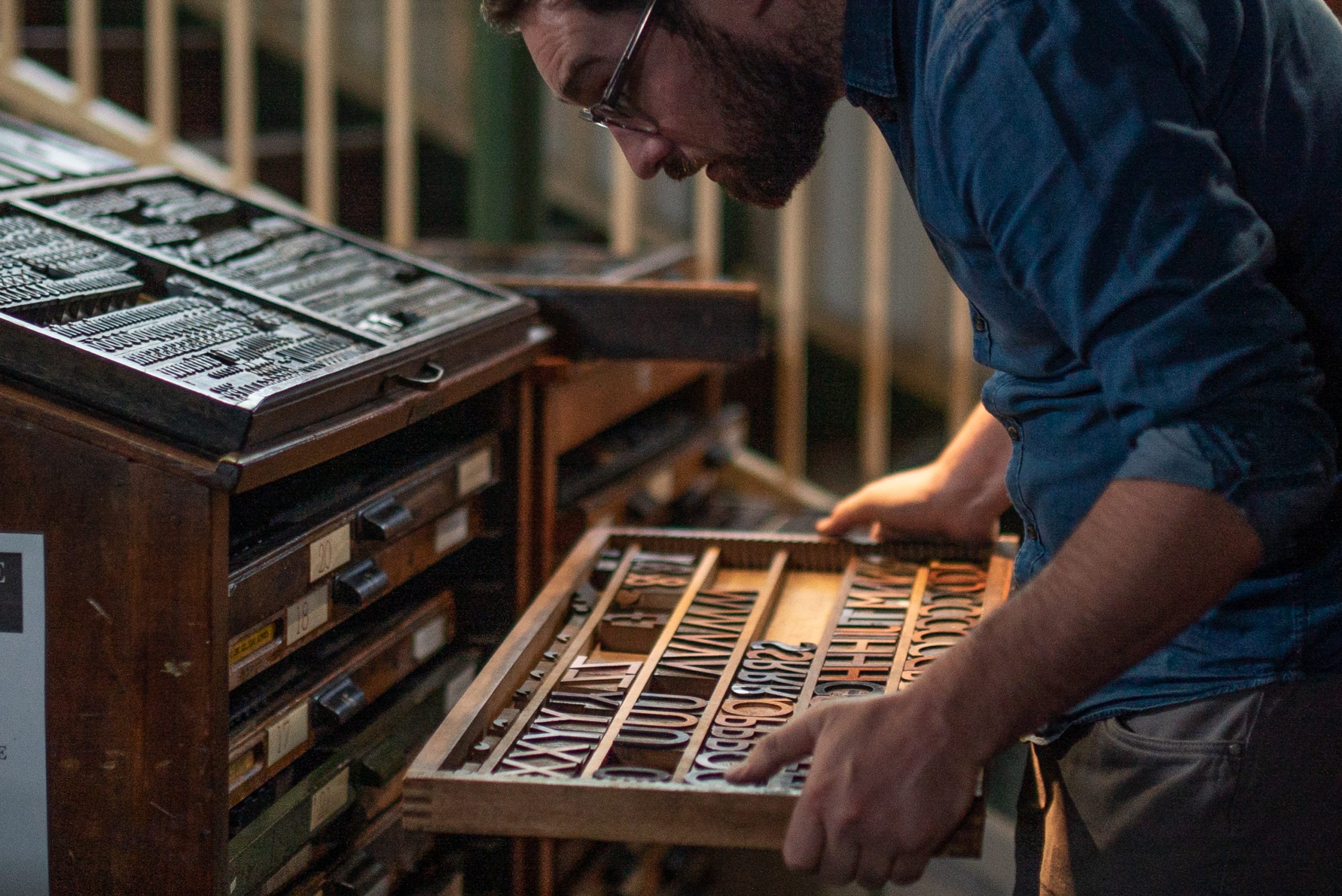 A workshop facilitator removing a case drawer full of woodtype letters