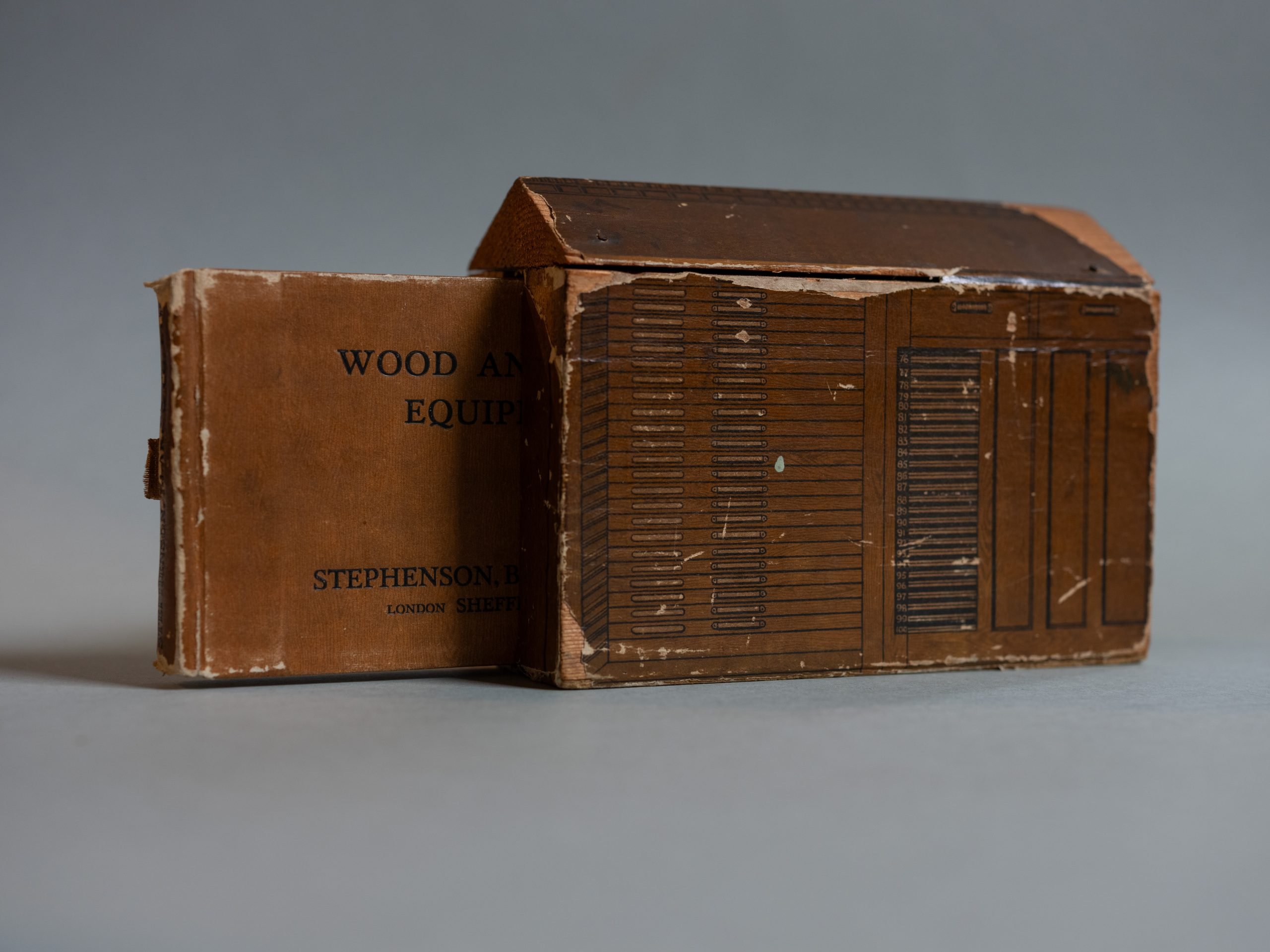 A worn catalogue of printing equipment that is shaped like a letterpress cabinet (pre-1971).