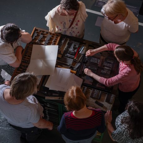 A group of participants gathered around the composing stone during a workshop