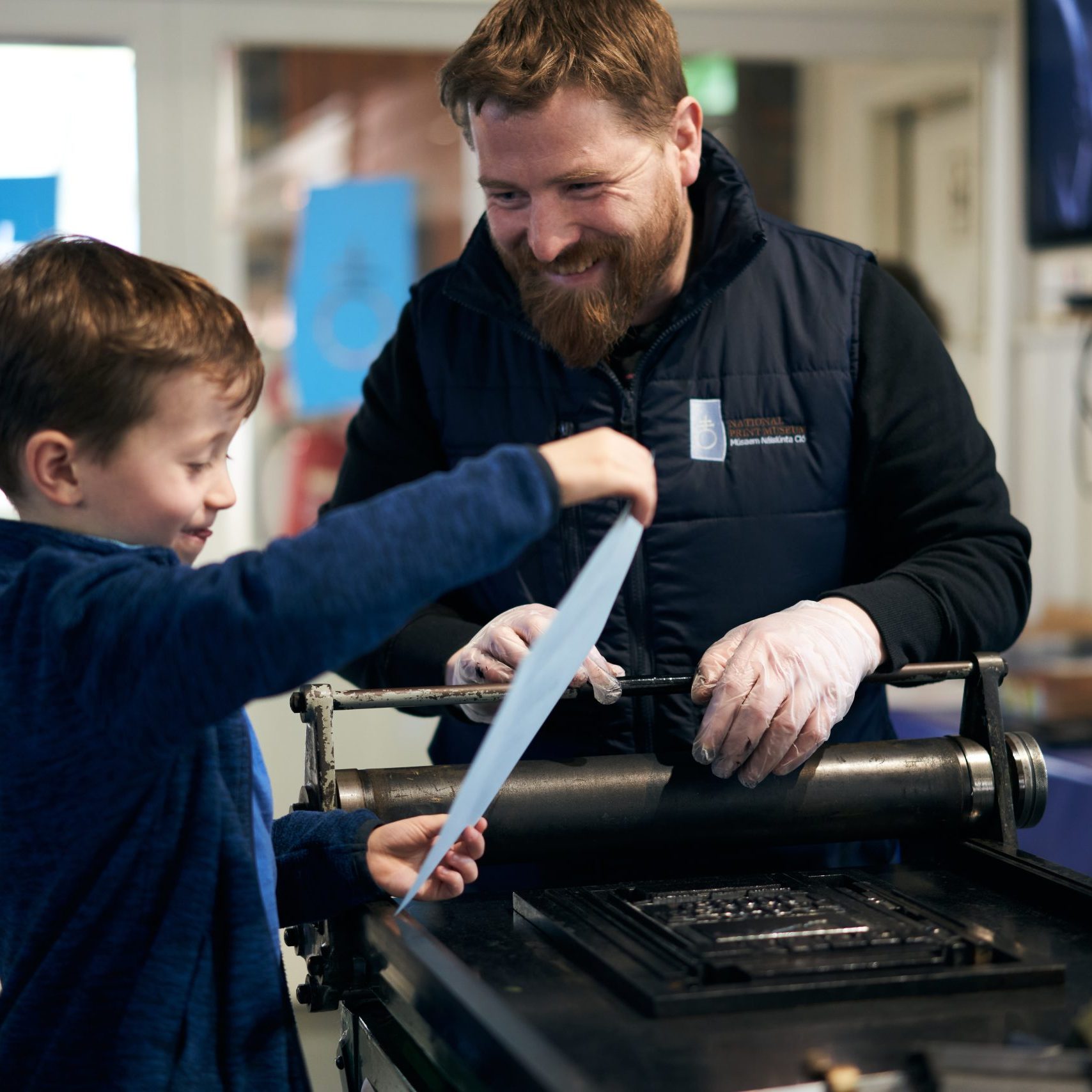 A student on the Culture and Heritage Course does a print demonstration with a visitor