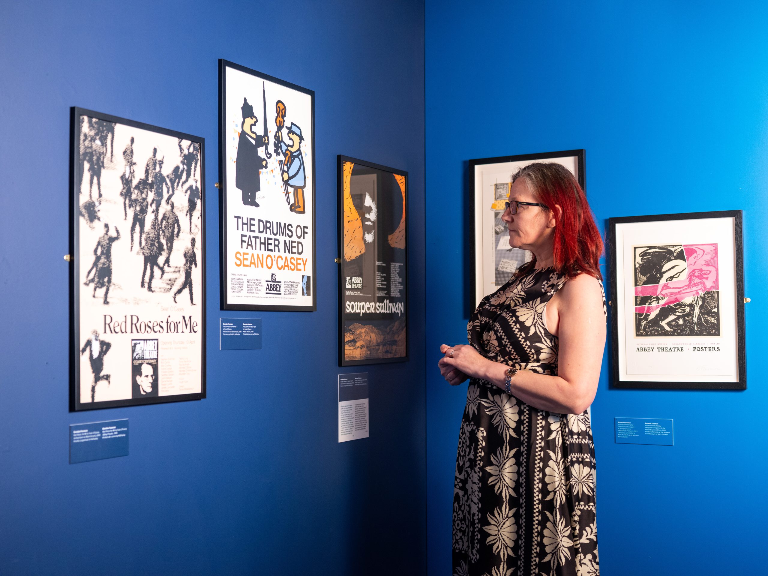 A visitor inspects theatre posters in the exhibition